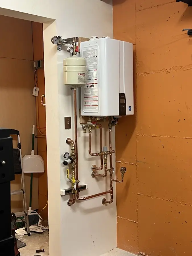 Plumbing technician inspecting water heater connections in Garnet